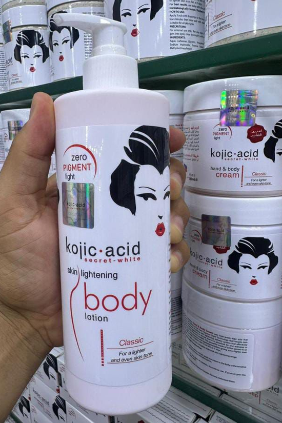 Kojic Acid body lotion held in a hand with shelves of similar products in the background.
