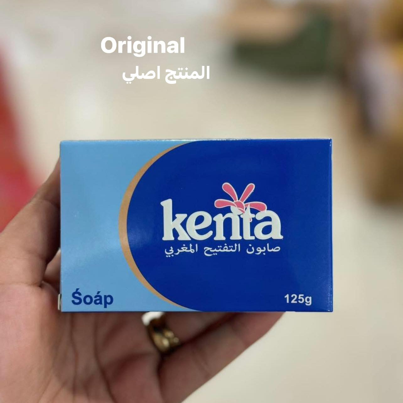 Kenta soap box held in a hand with a blurred background