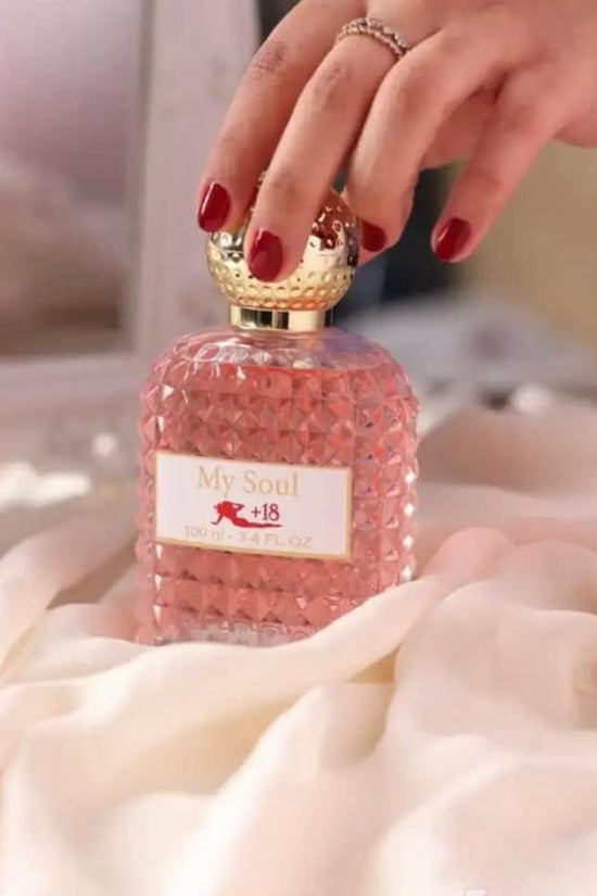 My Soul perfume women's 100ml in a pink faceted bottle with a gold cap, elegantly placed on soft fabric.