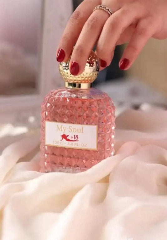 My Soul perfume women's 100ml in a pink faceted bottle with a gold cap, elegantly placed on soft fabric.