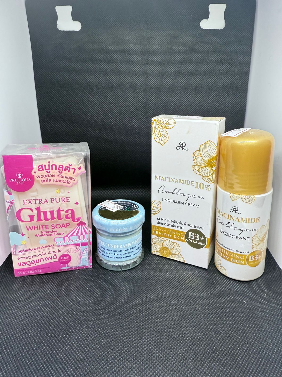 Collection of skincare and personal care products on a gray surface with a black background.
