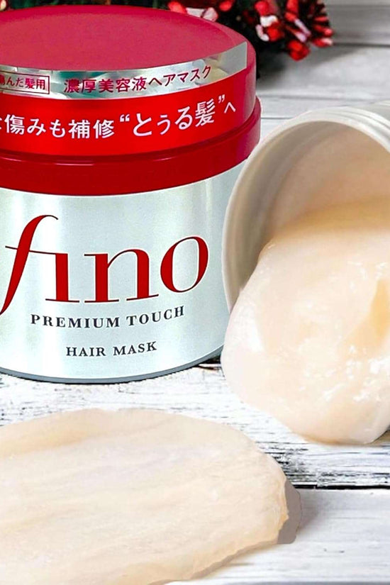 Fino hair mask Japan in a red container with creamy hair treatment spilled on the side
