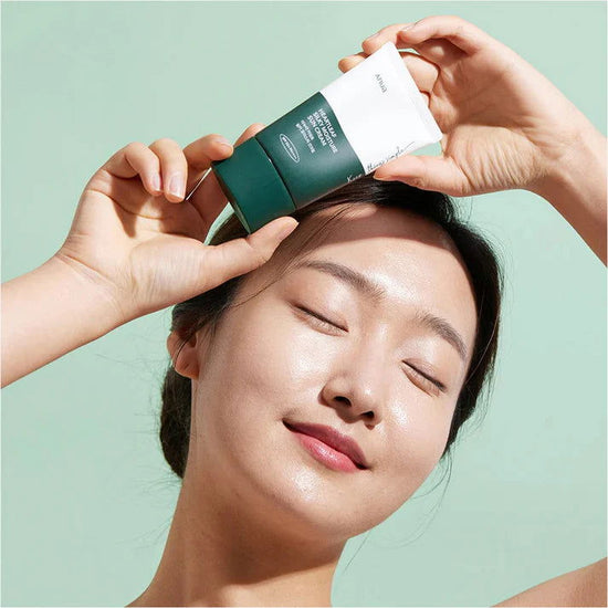 Anua Heartleaf Sunscreen 50ml displayed with a model showcasing its hydrating texture on the skin